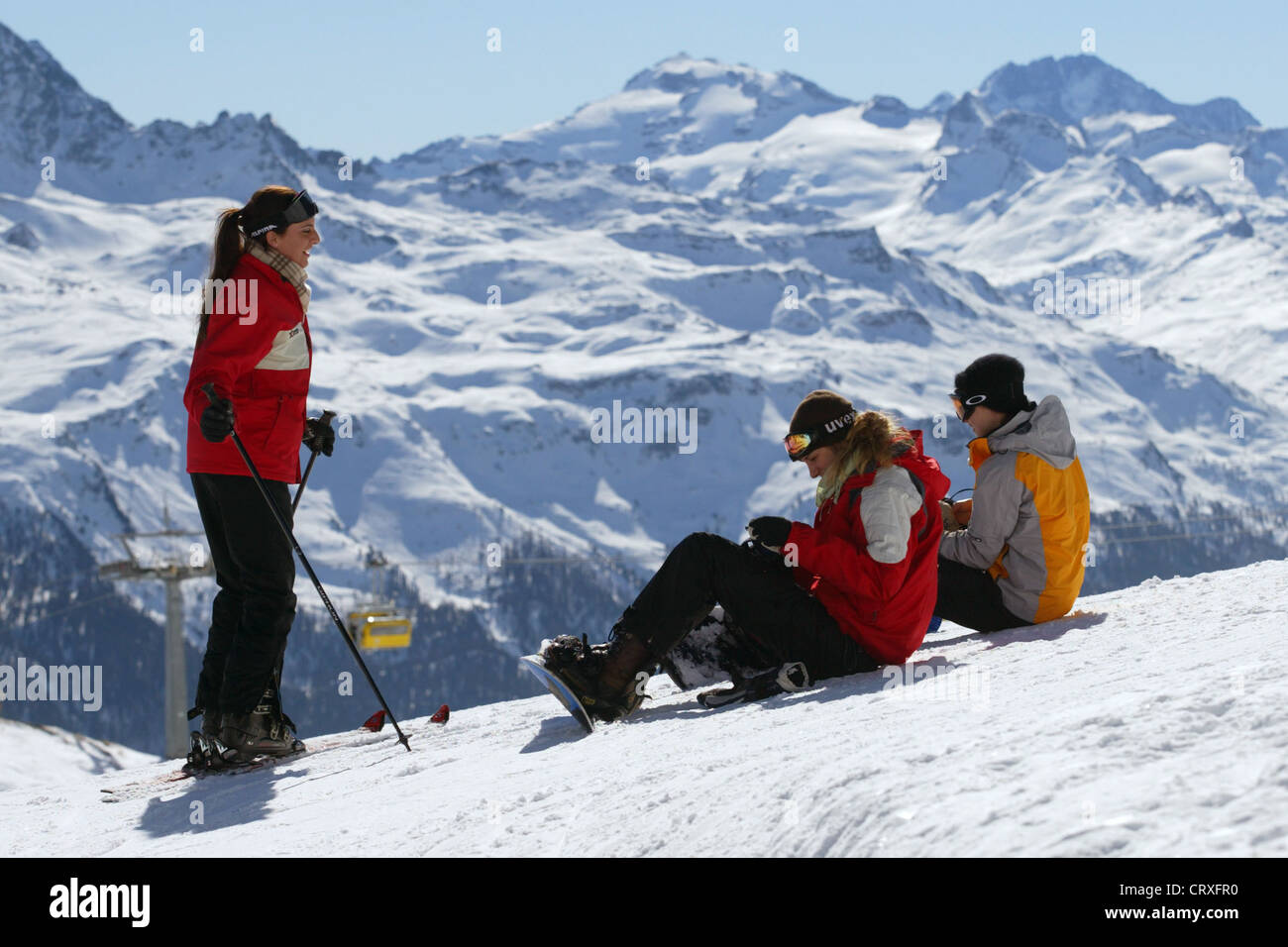 Sciatore e due amanti dello snowboard sulle piste da sci Foto Stock