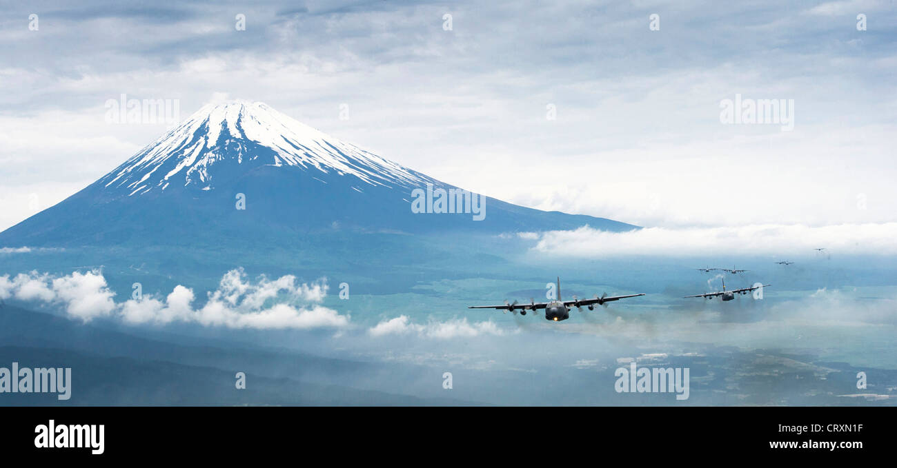 Una formazione della US Air Force C-130 Hercules aeromobili cargo volare in formazione come passano il Monte Fuji Giugno 5, 2012 in Giappone, . A 12,388 piedi, il Monte Fuji è la montagna più alte in Giappone. Foto Stock
