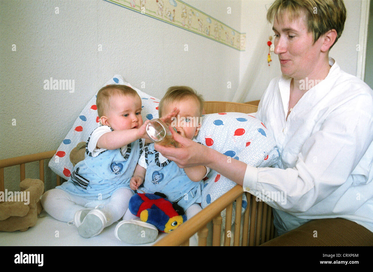Madre di alimentazione doppia femmina neonati, Berlino Foto Stock