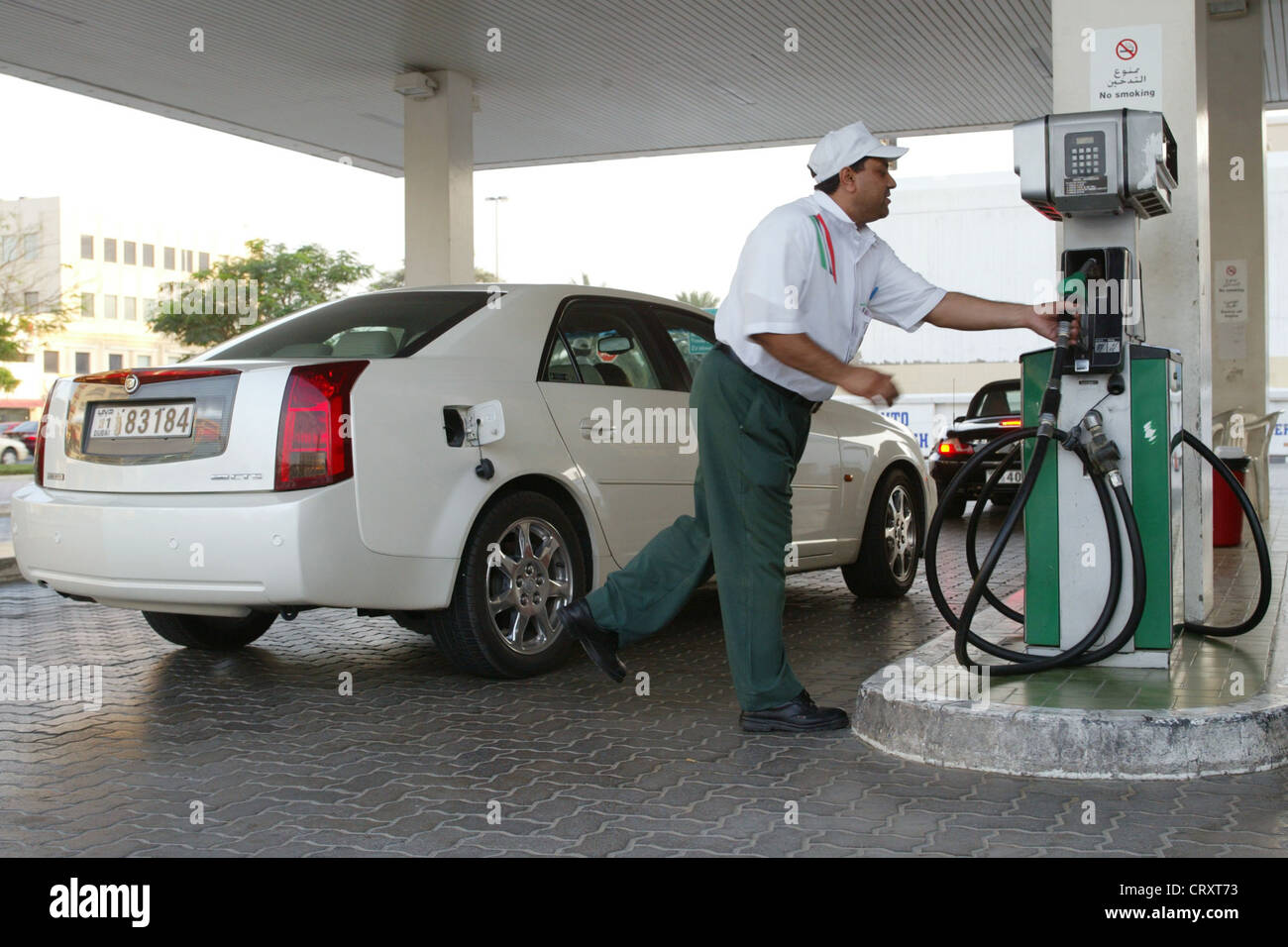 Attendant effettua il rifornimento di carburante di un auto in una stazione di benzina, Dubai Foto Stock