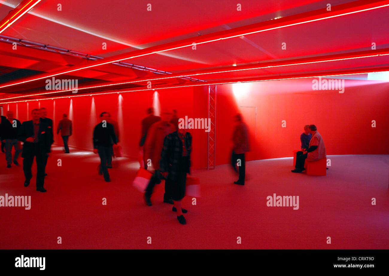 La gente passare attraverso un ingranaggio rosso, e.on AGM a Essen Foto Stock