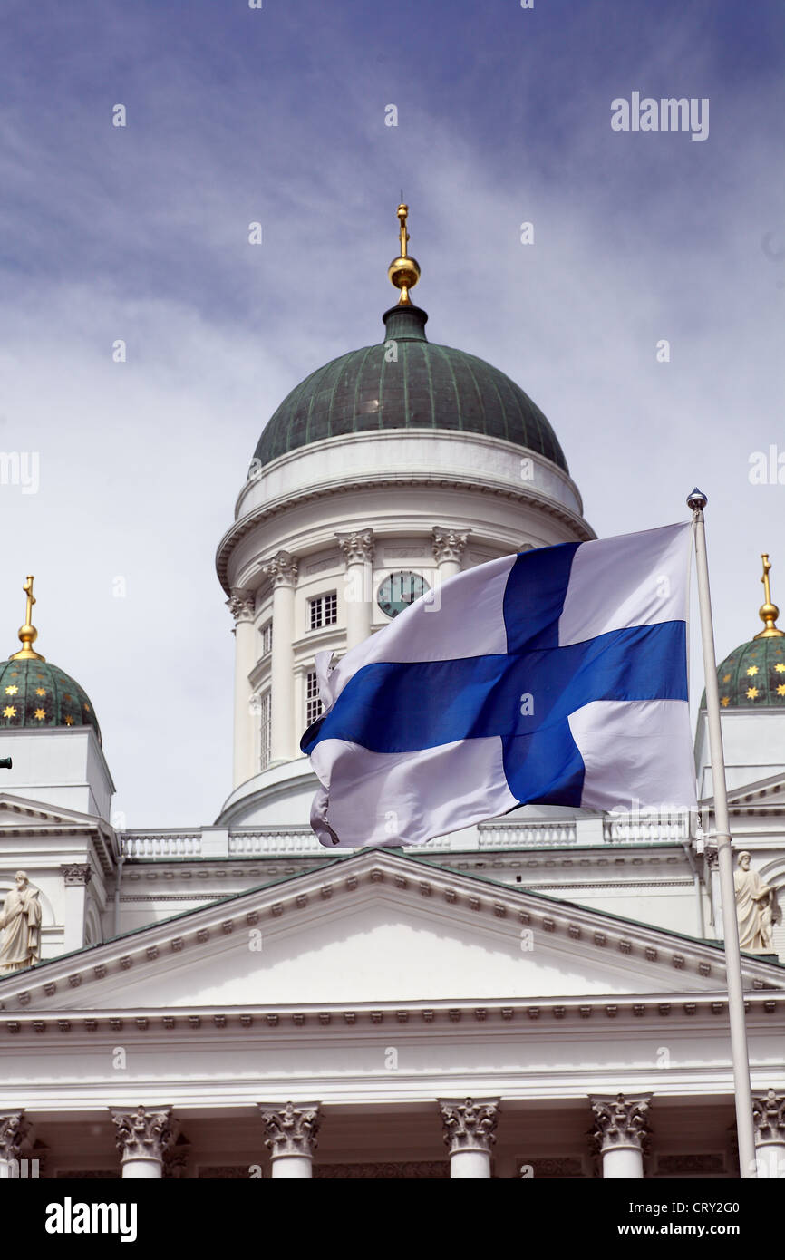 Svolazzanti bandiera nazionale della Finlandia contro la Cattedrale di Helsinki, più prominente edificio e simbolo della città Foto Stock