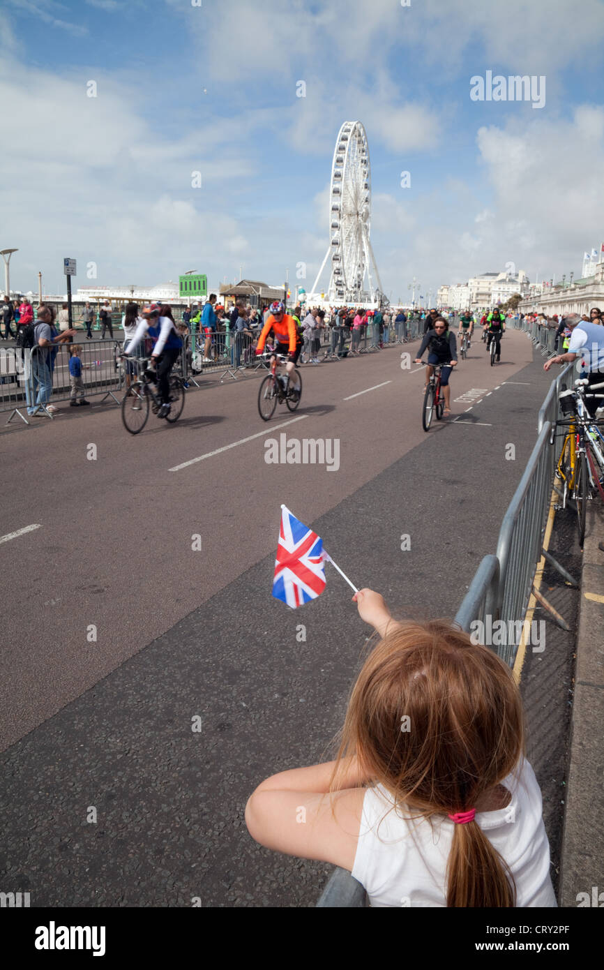 Bambini che sventolano la bandiera Union Jack al termine della corsa da Londra a Brighton Charity Cycle per il BHF a Brighton, Sussex UK Foto Stock