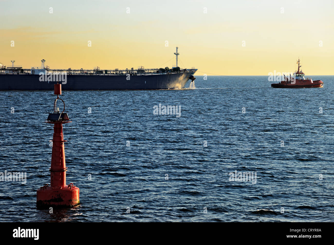Boa rosso sul fairway e petroliera in uscita in mare. Foto Stock