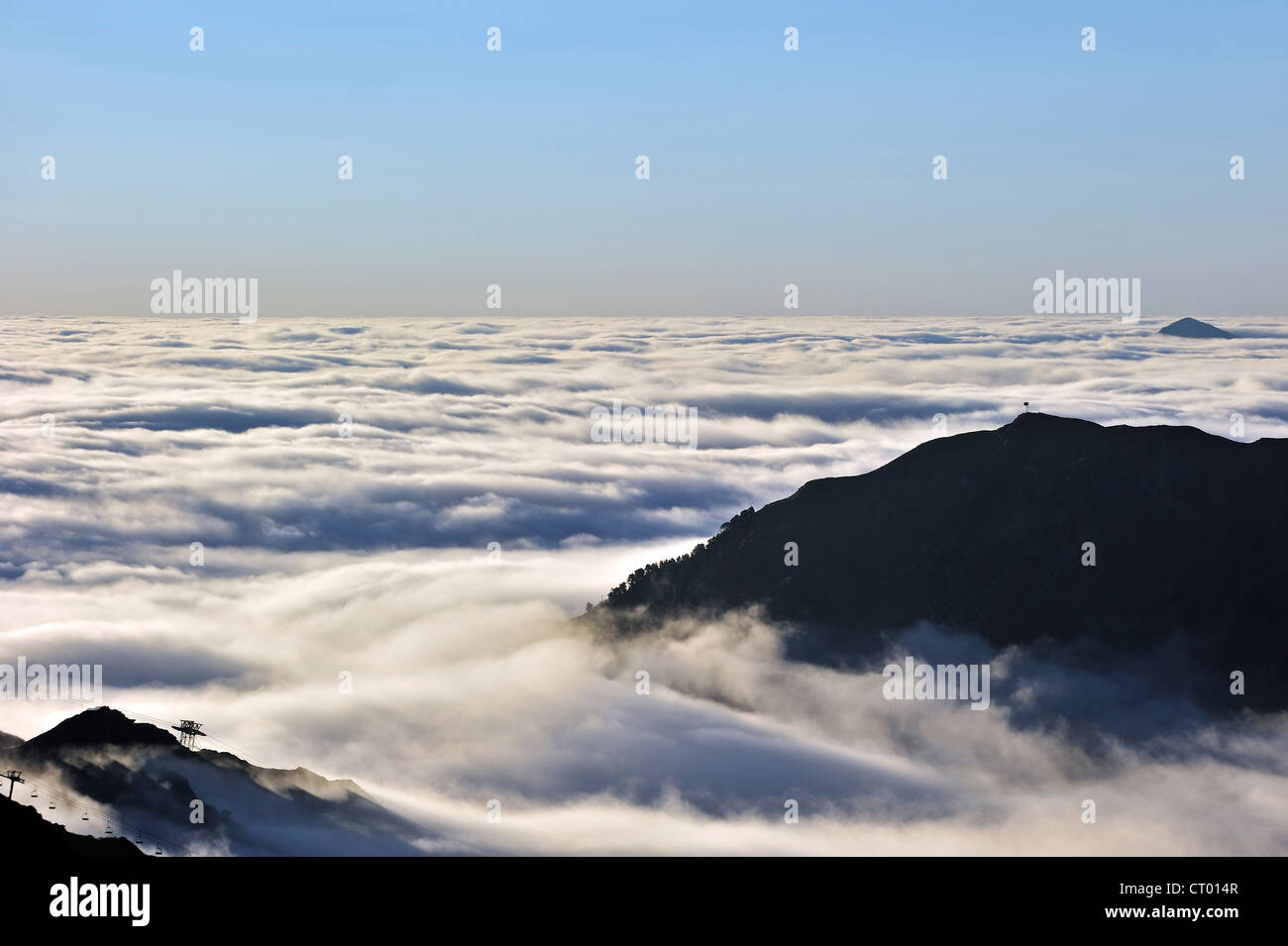 Vista su stagliano le seggiovie e le montagne coperte dalla nebbia di sunrise, Col du Tourmalet, Hautes-Pyrénées, Pirenei, Francia Foto Stock