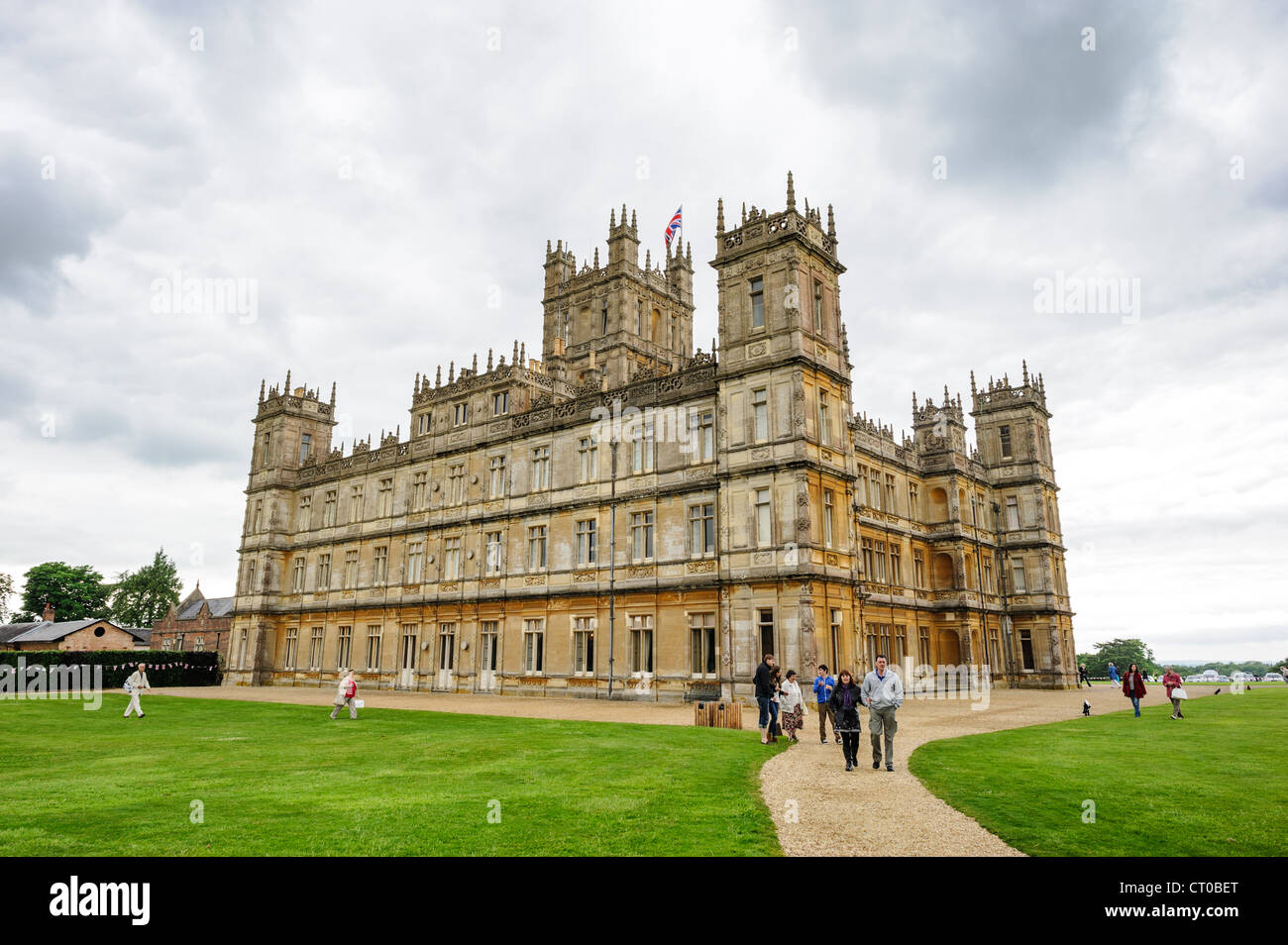 NEWBURY, Hampshire, Inghilterra - i visitatori camminano lungo i giardini fuori Highclere Castle, la casa di campagna di epoca vittoriana che ha guadagnato fama mondiale come location principale per le riprese della serie televisiva "Downton Abbey". L'edificio classificato di grado i, completato nel 1878, serve come sede di campagna del conte di Carnarvon ed è stato nella famiglia Carnarvon dal 1679. Il caratteristico stile architettonico giacobano del castello fu progettato da Sir Charles Barry, che progettò anche le Houses of Parliament a Londra. Highclere Castle accoglie ogni anno migliaia di turisti che vengono a esplorare il suo gra Foto Stock