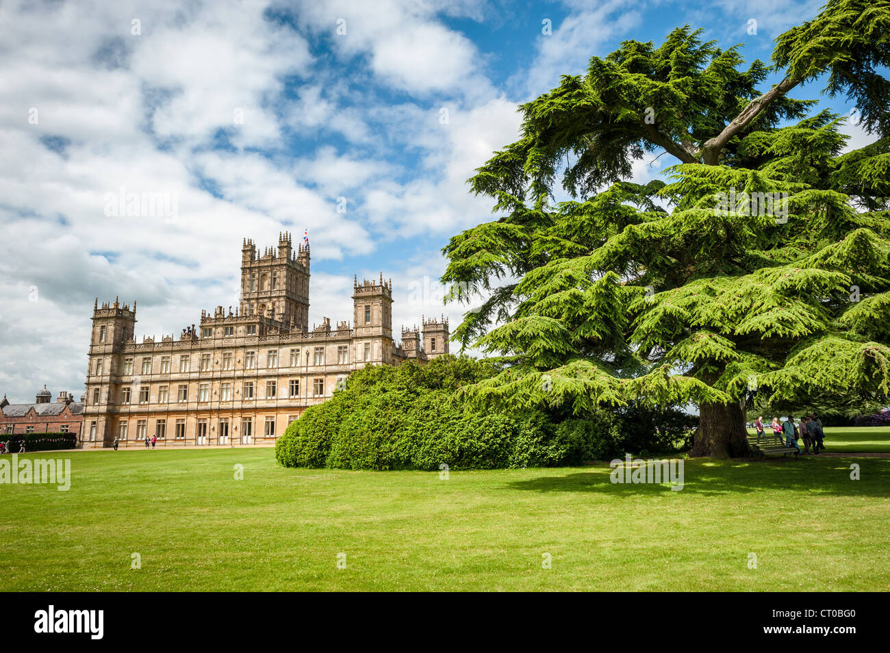 HIGHCLERE CASTLE, Hampshire, Inghilterra - Highclere Castle si erge maestosamente come la casa ancestrale del conte e contessa di Carnarvon nella campagna ondulata dell'Hampshire. La casa di campagna dell'epoca vittoriana ha ottenuto il riconoscimento internazionale come location principale per le riprese dell'acclamato film d'epoca britannico "Downton Abbey", creato da Julian Fellowes. Il castello in stile giacobano, progettato da Sir Charles Barry nel XIX secolo, presenta torri caratteristiche e una facciata elaborata che è diventata iconica per gli spettatori di tutto il mondo. La tenuta comprende circa 5.000 ettari di parco, des Foto Stock