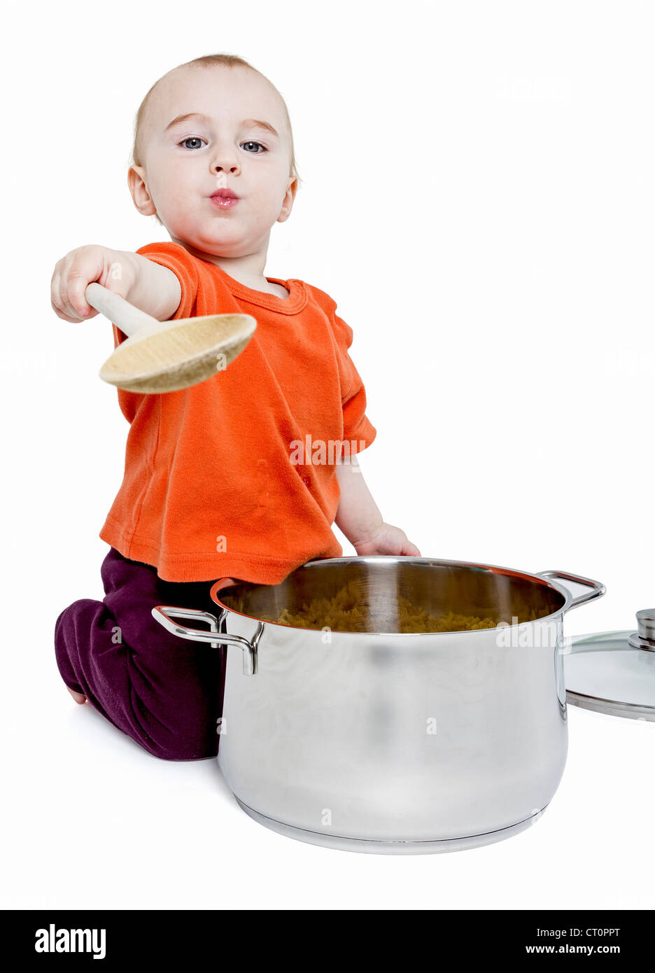 Bambino con grande pentola di cottura e il cucchiaio di legno isolato su sfondo bianco Foto Stock