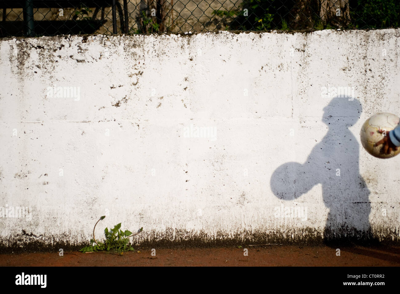 Ombra di un ragazzo sulla parete giocare a palla. Foto Stock