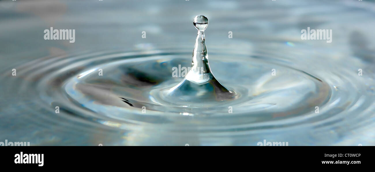 Singola Goccia d'acqua spruzzi in acqua chiara Foto Stock