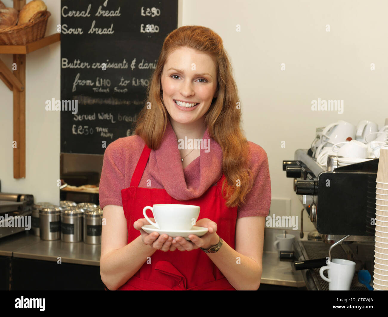 Server con caffè dietro il contatore da forno Foto Stock