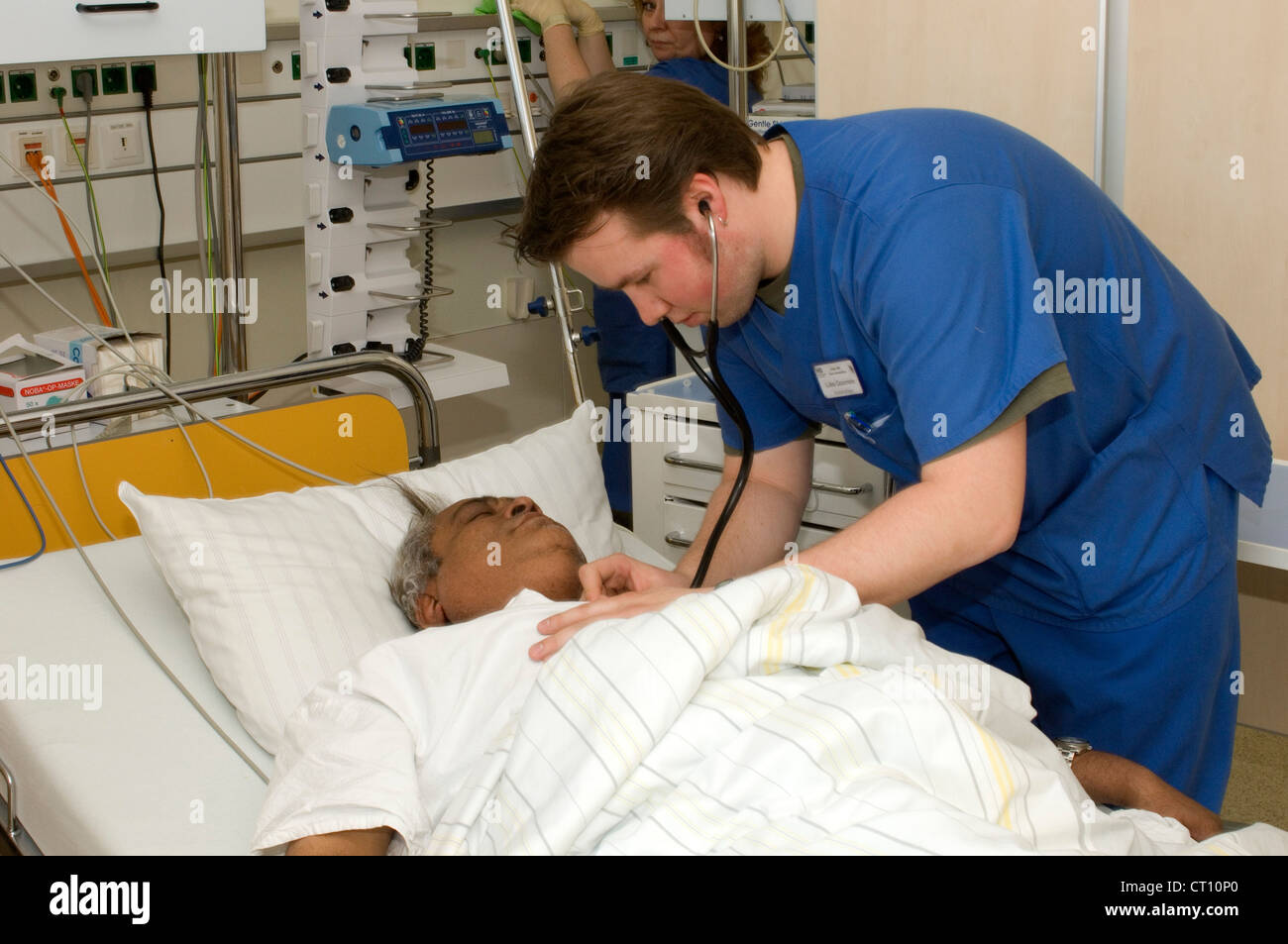 Un medico esamina un paziente che era stato ricoverato in un ospedale di incidenti e dipartimento di emergenza con gravi dolori di stomaco. Foto Stock