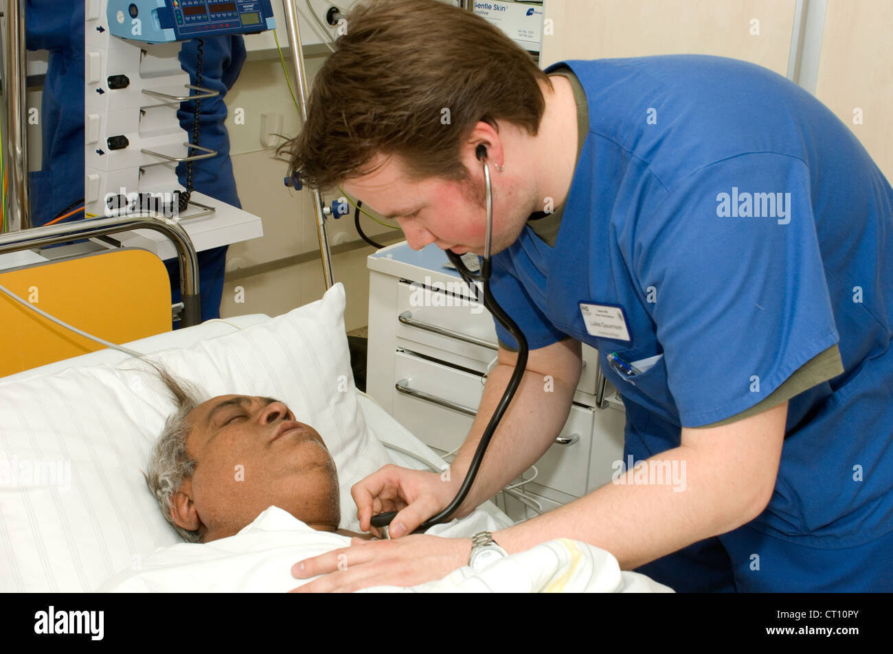Un medico esamina un uomo che è stato ricoverato in un ospedale di incidenti e dipartimento di emergenza con gravi dolori di stomaco. Foto Stock