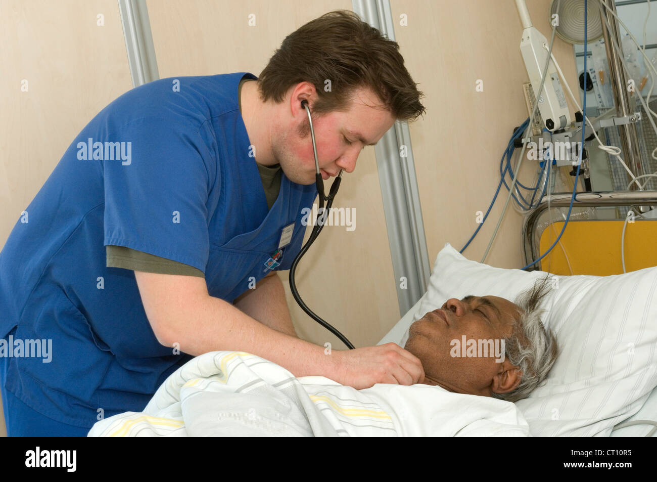 Un medico esamina un uomo che è stato ricoverato in un ospedale di incidenti e dipartimento di emergenza con gravi dolori di stomaco. Foto Stock