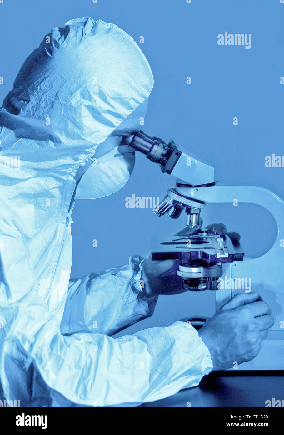 Scienziato in un microscopio Foto Stock