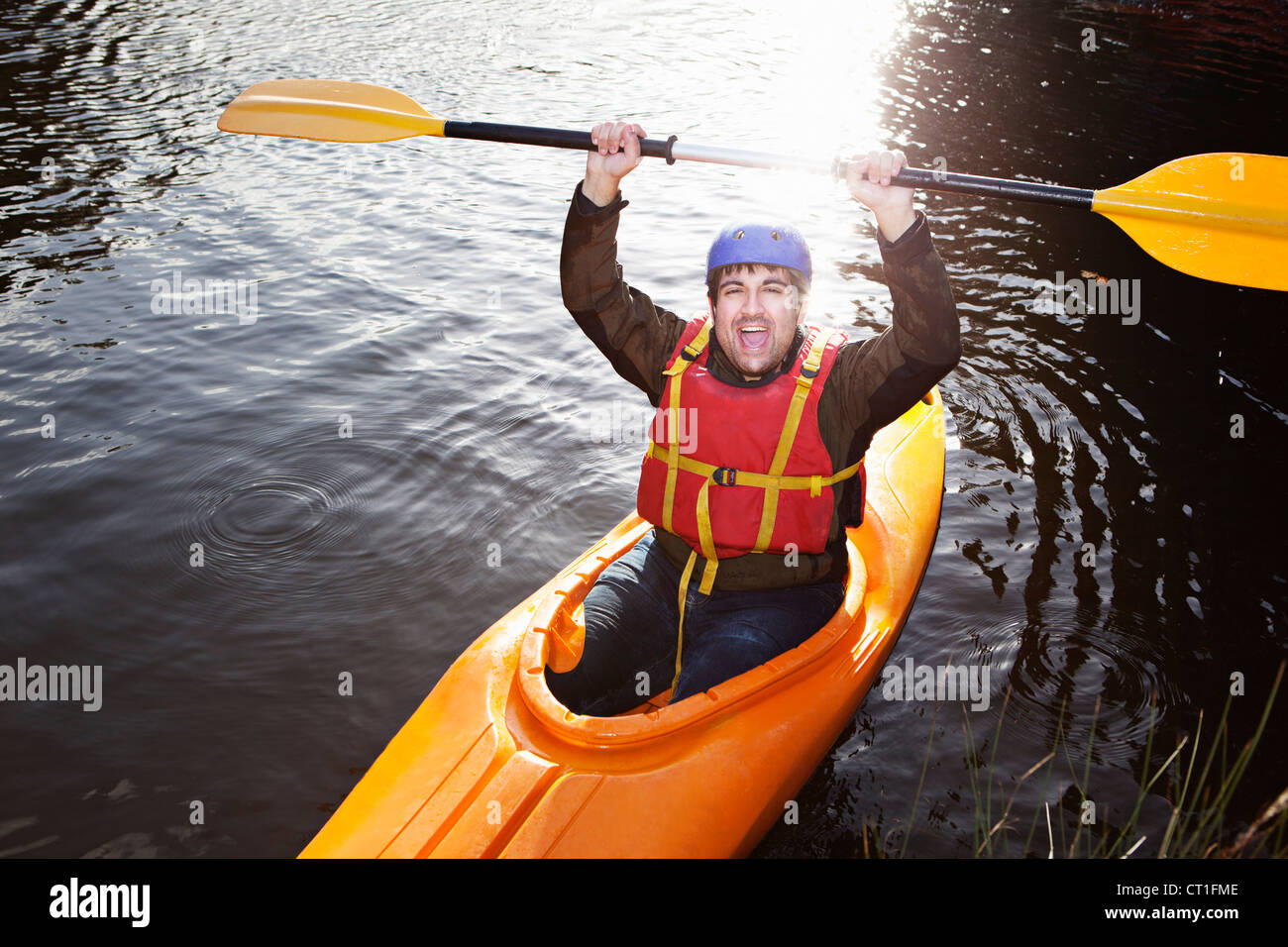 Kayaker holding oar nel lago ancora Foto Stock