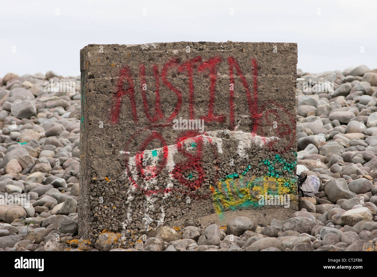 Seconda guerra mondiale cisterna di cemento blocco trap sulla spiaggia di ciottoli con graffiti Foto Stock