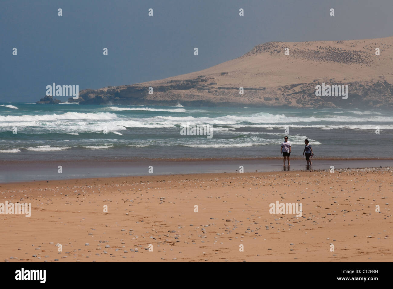 Due donne a camminare su una spiaggia deserta vicino a Agadir sulla costa atlantica, Marocco, Africa Foto Stock