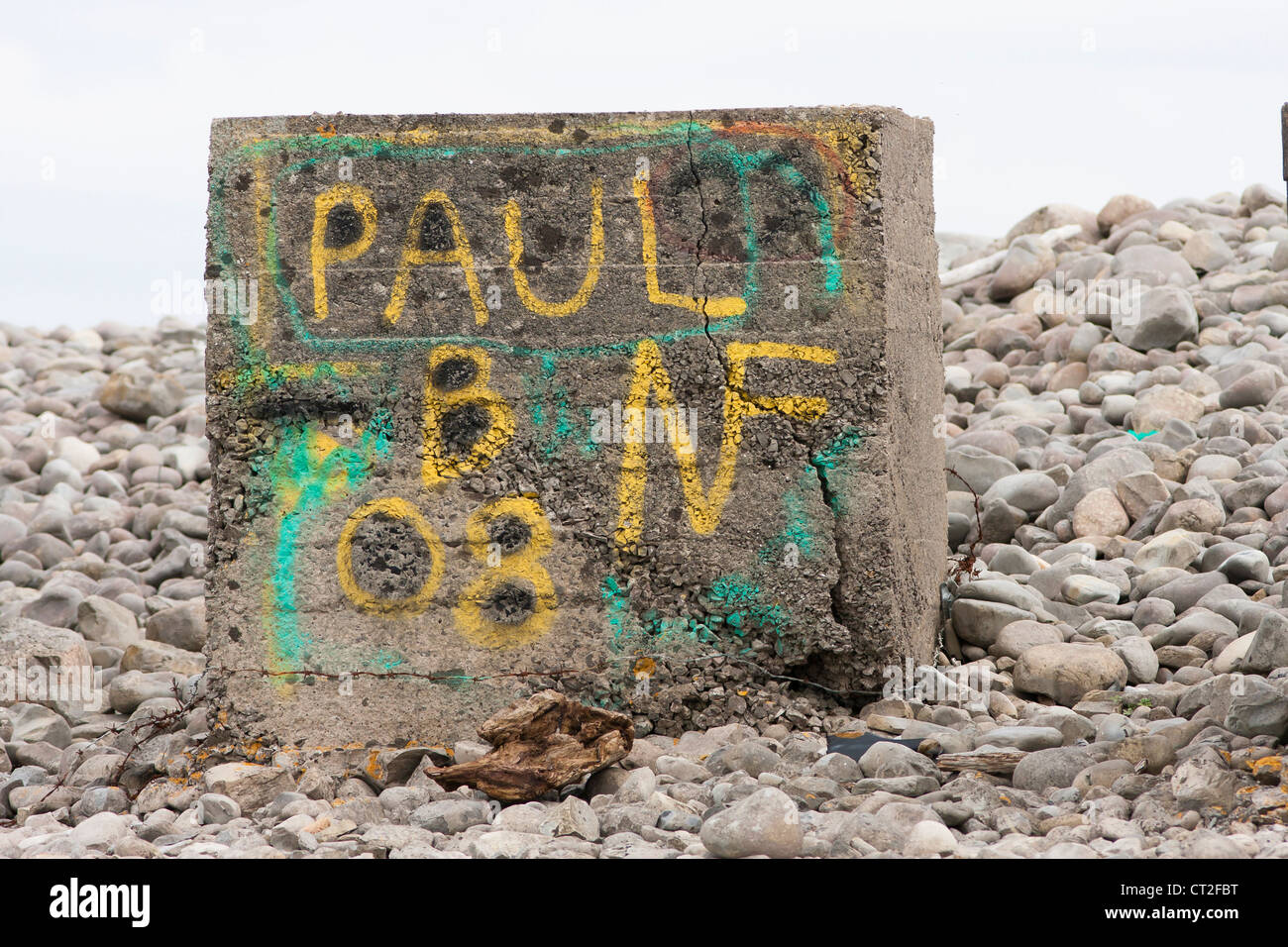 Seconda guerra mondiale cisterna di cemento blocco trap sulla spiaggia di ciottoli con graffiti Foto Stock