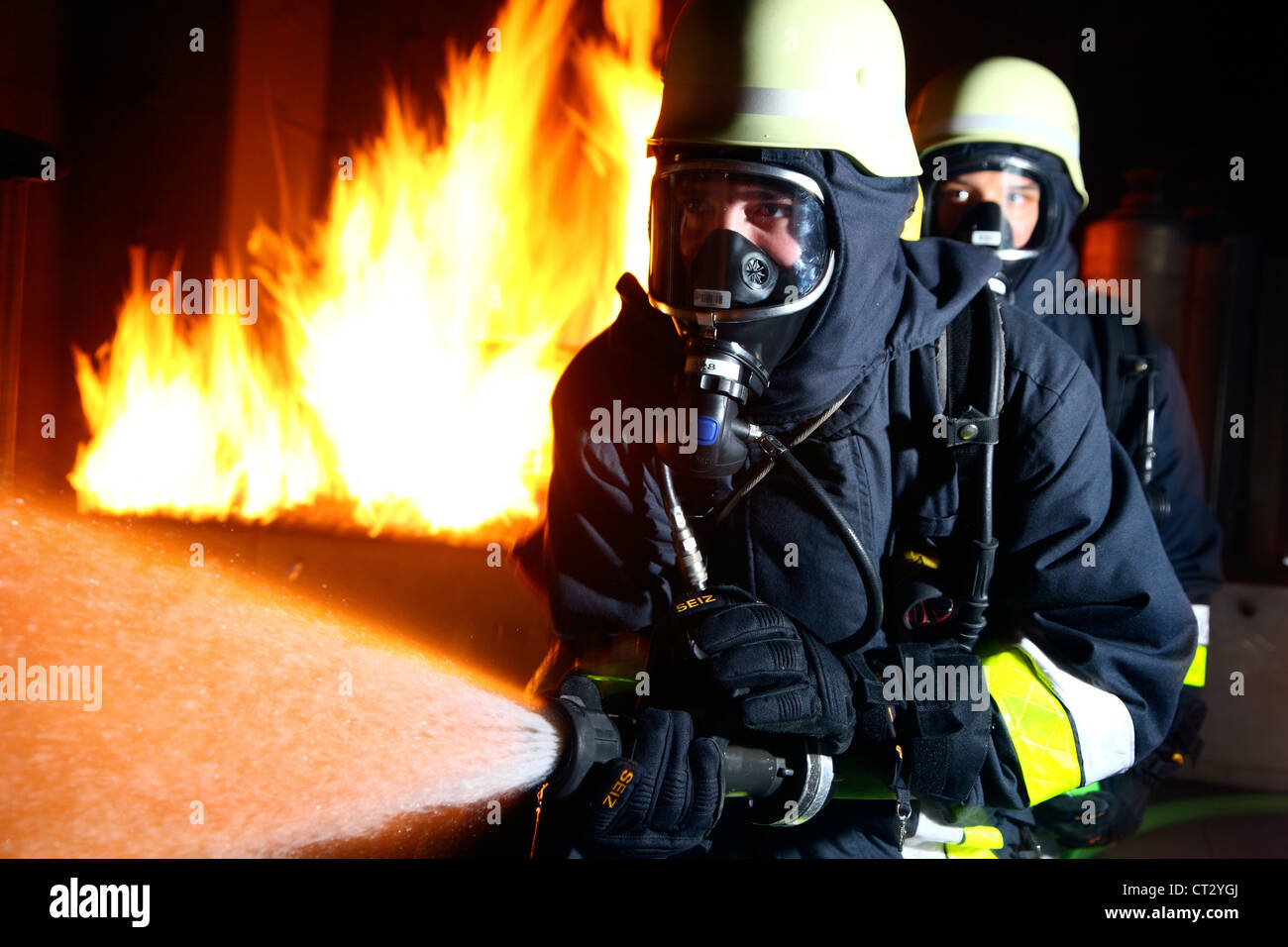 I vigili del fuoco, il fuoco agli uomini, scontri a fuoco la formazione a un incendio nella casa di formazione. I vigili del fuoco con apparecchi di respirazione. Foto Stock