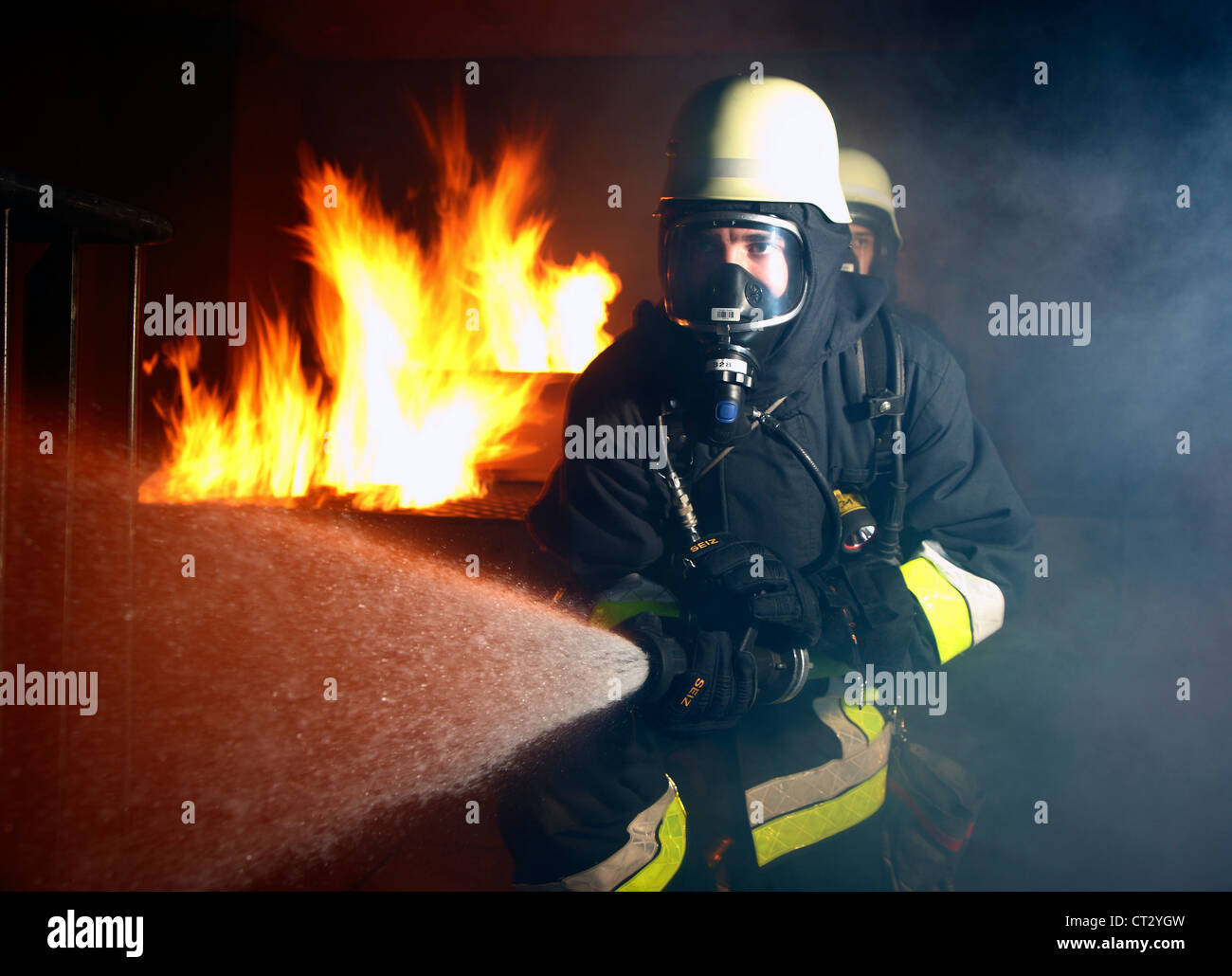 I vigili del fuoco, il fuoco agli uomini, scontri a fuoco la formazione a un incendio nella casa di formazione. I vigili del fuoco con apparecchi di respirazione. Foto Stock