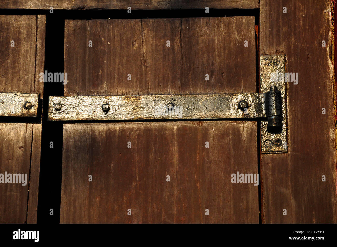Antiche in legno porta con cerniere in metallo. Foto Stock