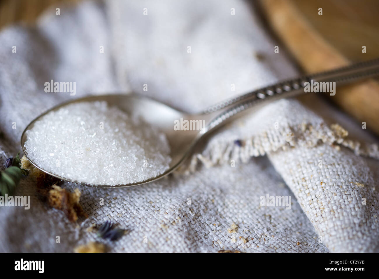 Macro still-life di cucchiaio da tè di zucchero bianco sulla tela di lino. DOF poco profondo Foto Stock