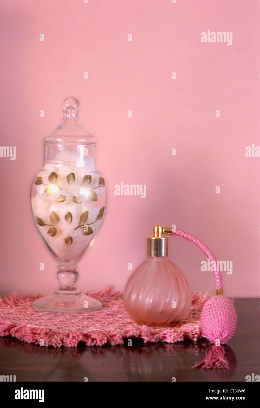 Una rosa vanity con cotone e una bottiglia di profumo. Foto Stock