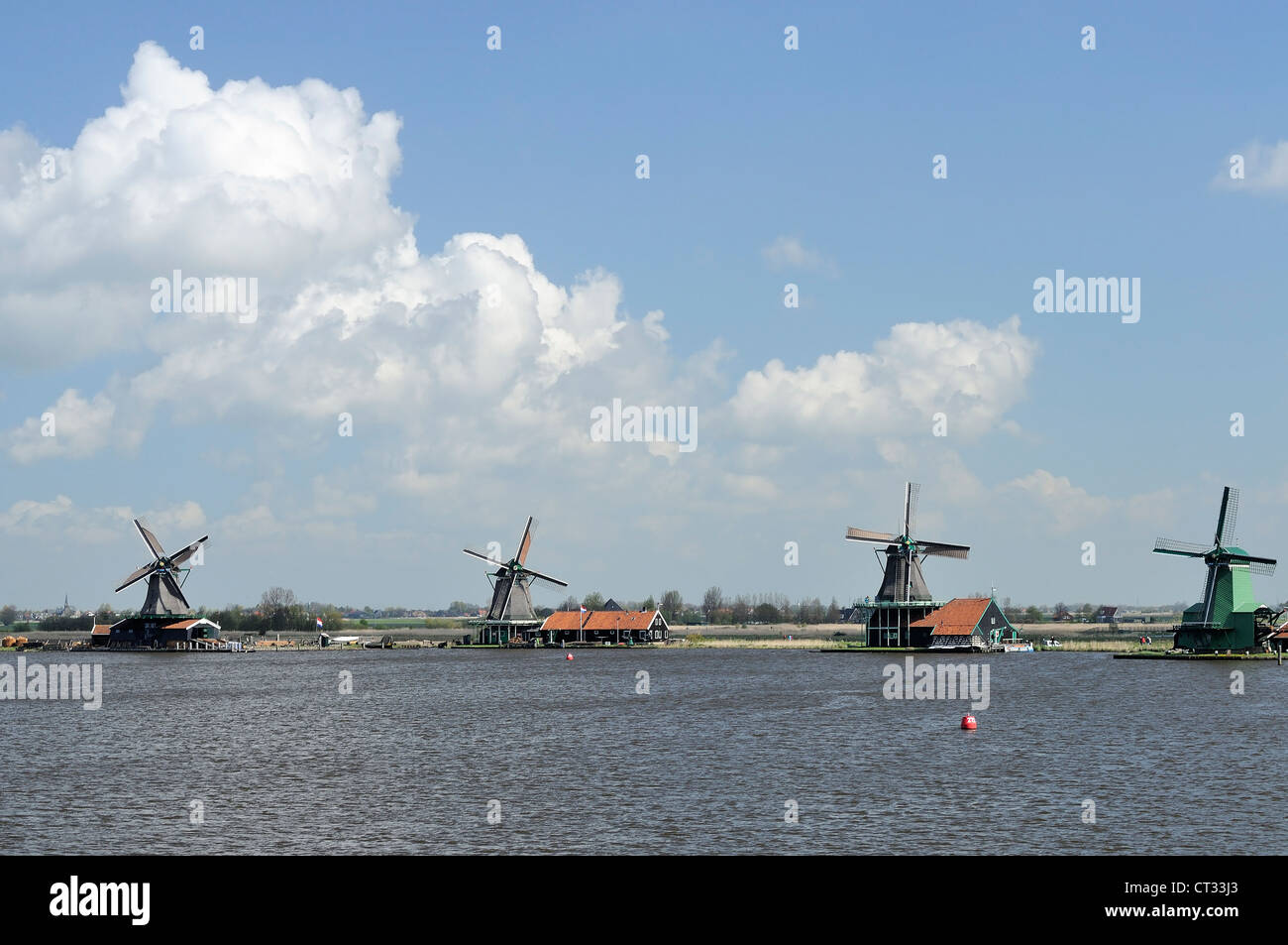 Mulini a vento fila, Zaanse Schans vista di mulini a vento tradizionali a località turistica, girato in condizioni di intensa luce a molla Foto Stock
