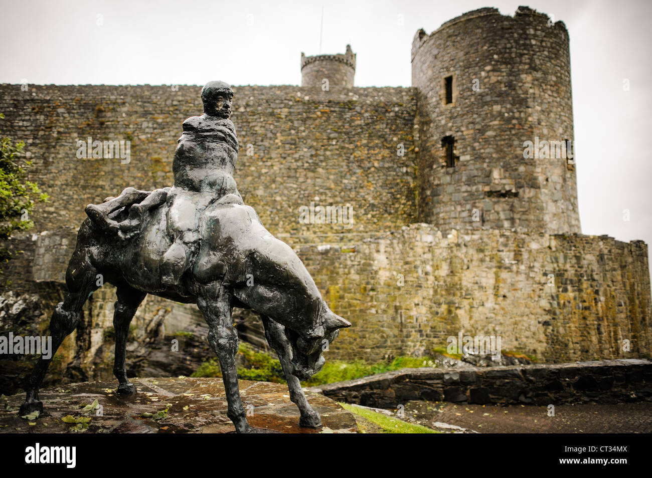 HARLECH, Galles - la statua dei due Re di Ivor Roberts-Jones si trova di fronte al castello di Harlech nel Gwynedd, Galles del Nord. Inaugurata nel 1984, la scultura raffigura una scena del Mabinogion gallese, con Bendigeidfran che porta suo nipote Gwern. Questa commovente opera d'arte contrasta con il castello del XIII secolo costruito da Edoardo i, parte dei "castelli e mura cittadine di Re Edoardo nel Gwynedd", patrimonio dell'umanità dell'UNESCO. Foto Stock
