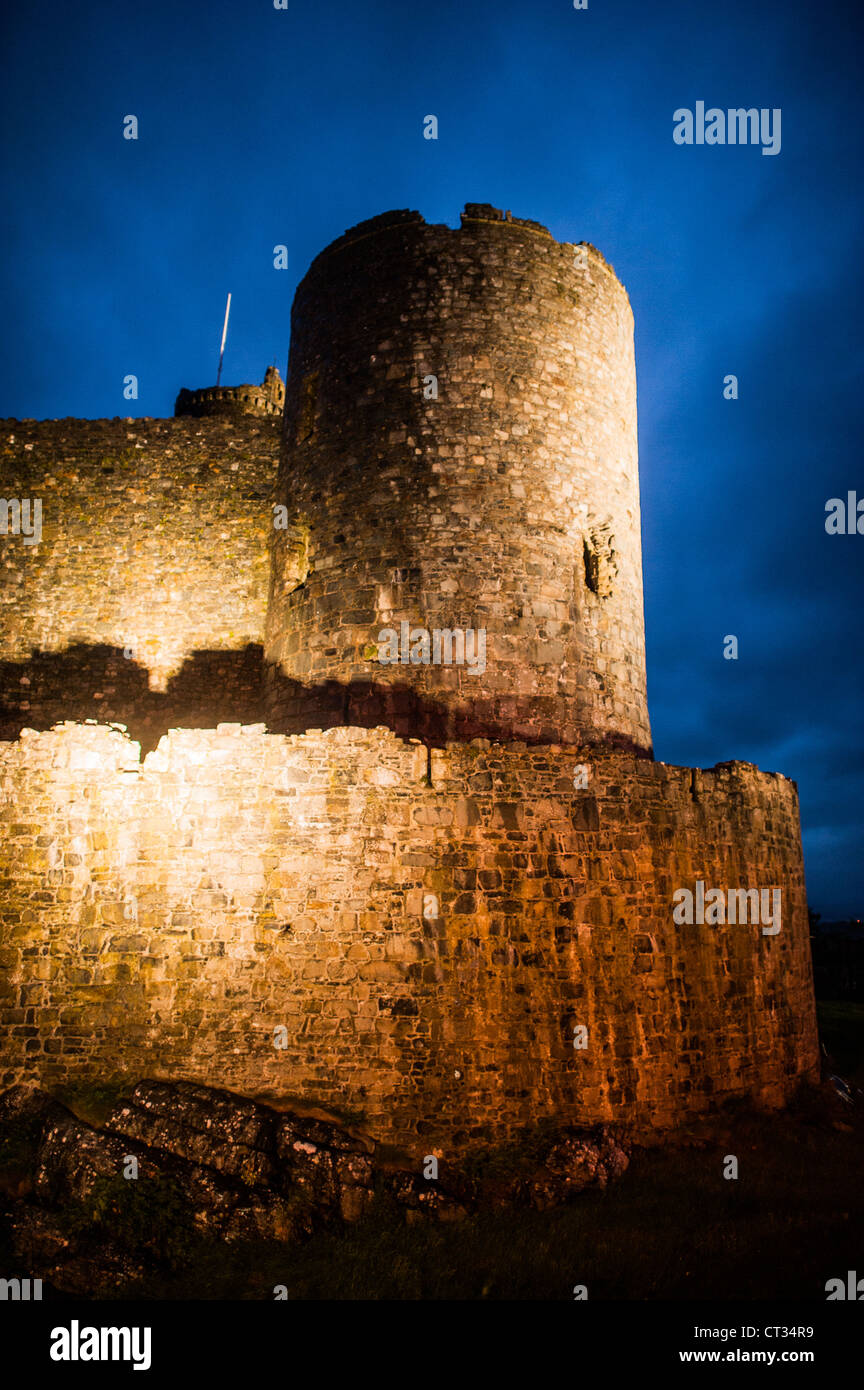 HARLECH, Galles - Harlech Castle, una fortezza del XIII secolo costruita da Edoardo i, si erge sagomata contro il cielo crepuscolo sulla costa nord-occidentale del Galles. La luce che svanisce accentua l'imponente profilo di questo sito patrimonio dell'umanità dell'UNESCO, mostrando la sua posizione strategica affacciata sul Mare d'Irlanda e evocando la grandiosità medievale di questo monumento storico. Foto Stock