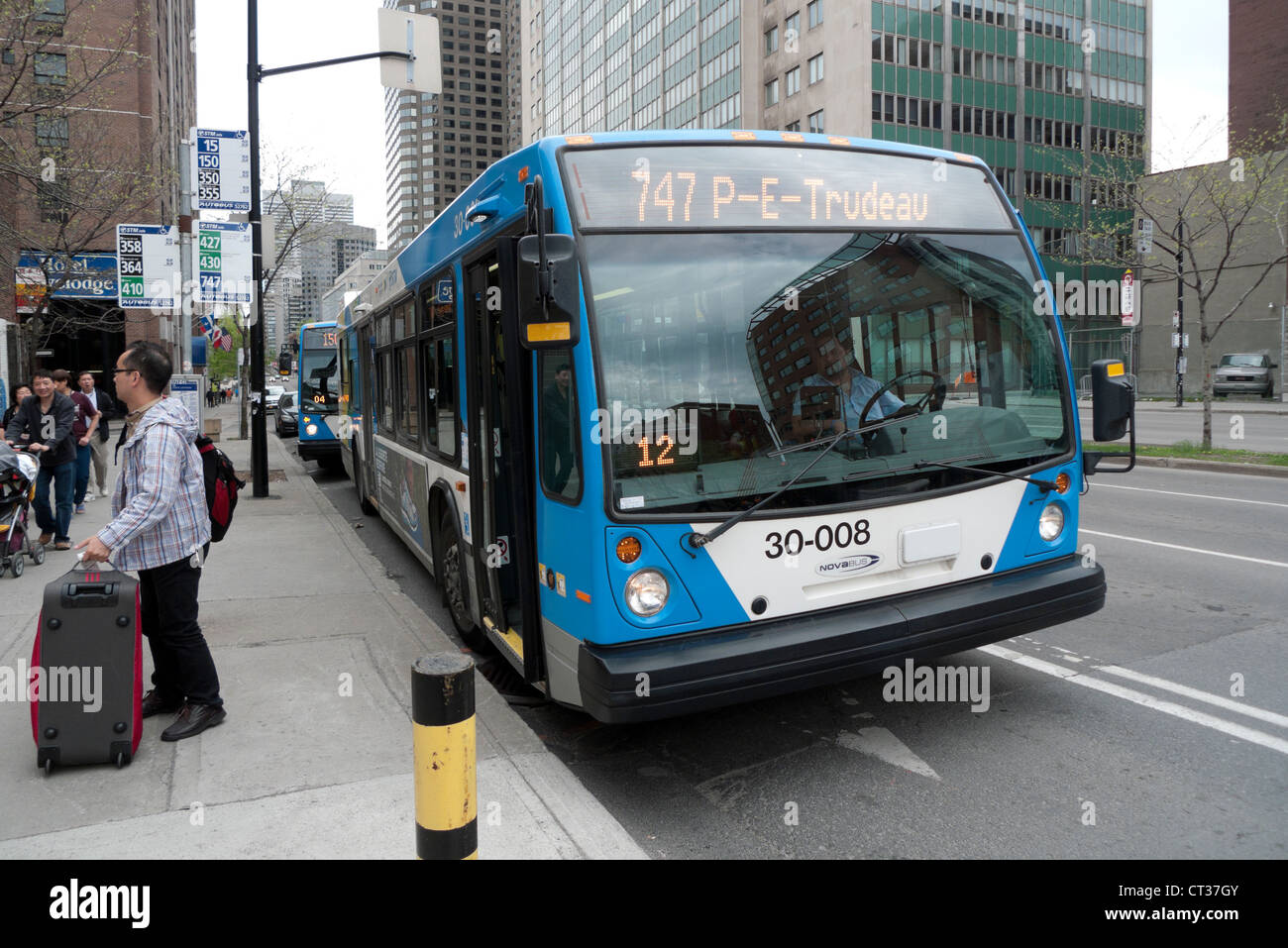 Passeggeri asiatici scende ad una fermata del bus da 747 Trudeau Airport bus sul Boulevard René-Lévesque Quebec Montreal vicino a Chinatown. Foto Stock