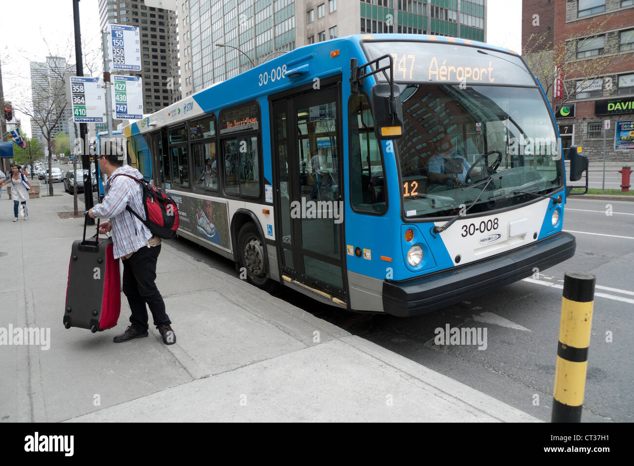 Passeggeri asiatici essendo lasciate fuori ad una fermata del bus da 747 Trudeau Airport bus su boul. René-Lévesque Quebec Montreal KATHY DEWITT Foto Stock