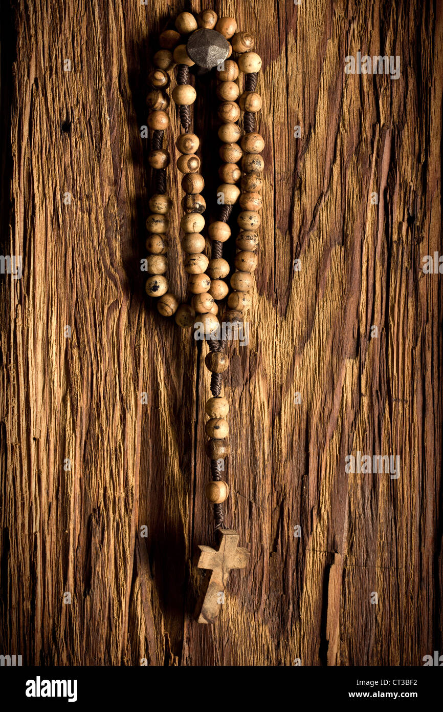 Legno perle di rosario appeso sul vecchio sfondo di legno Foto Stock