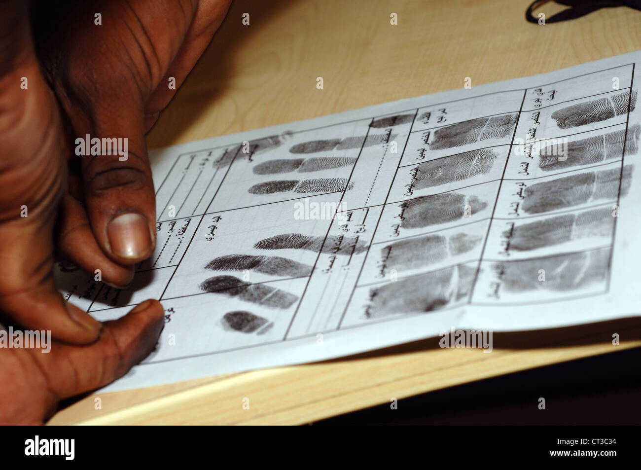 Un sospetto criminale ha loro prendere le impronte digitali. Foto Stock