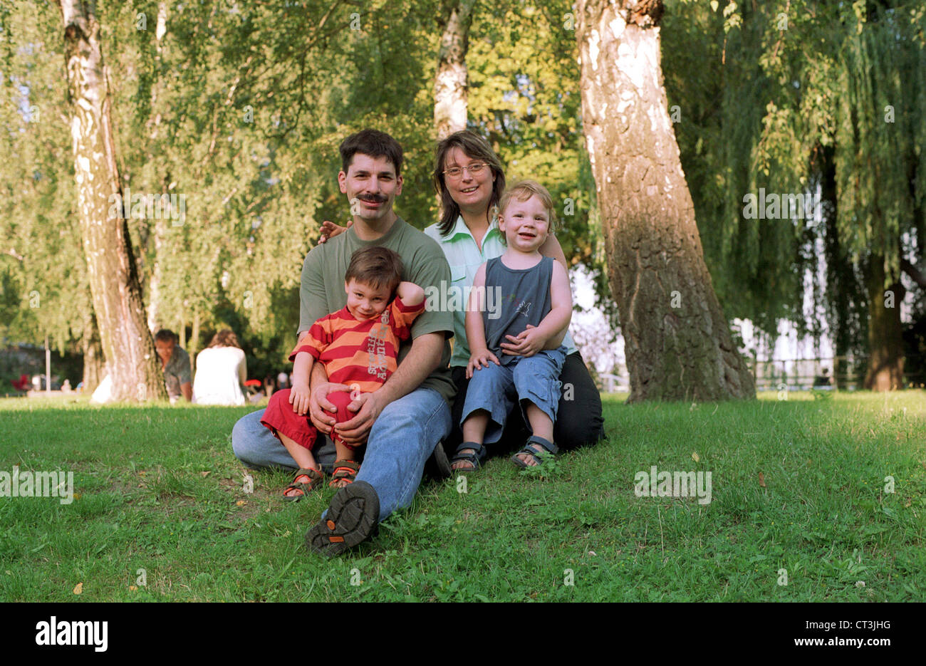 Berlino, famiglia con bambini seduti su un prato Foto Stock