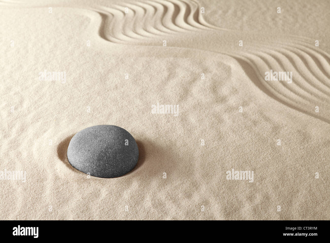 Giardino zen e la meditazione di sabbia concetto di pietra per l'equilibrio della spiritualità di armonia e la semplicità di un round rock e un modello in sabbia Foto Stock