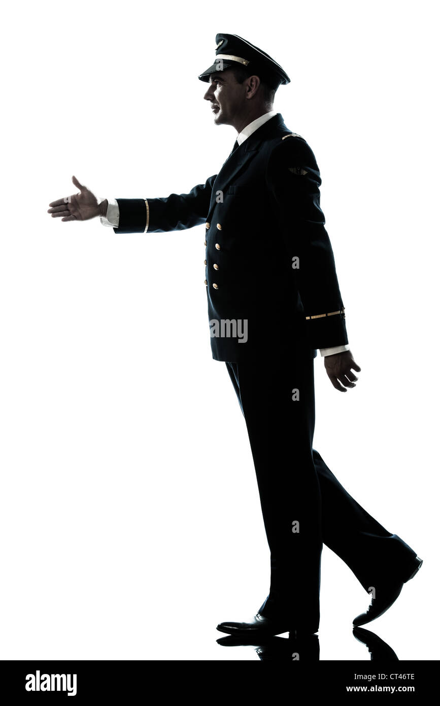 Un uomo caucasico in compagnia aerea uniforme pilota a piedi silhouette di handshake in studio isolato su sfondo bianco Foto Stock
