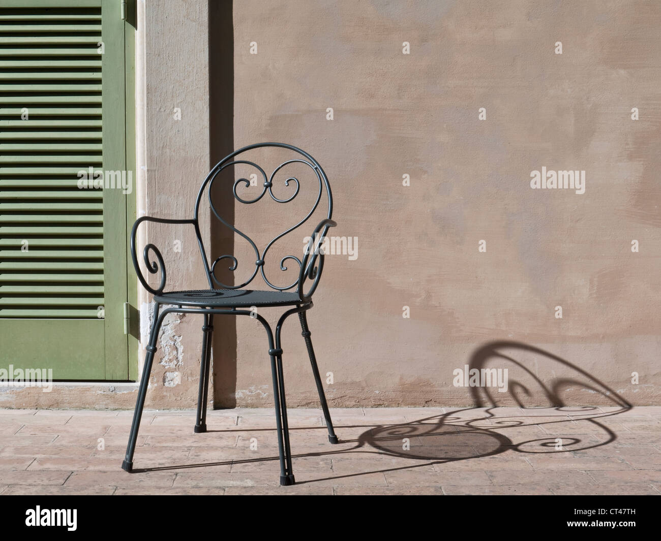 Persiane e ferro battuto sedia in sole e ombra, Grottaferrata, Roma, Italia Foto Stock