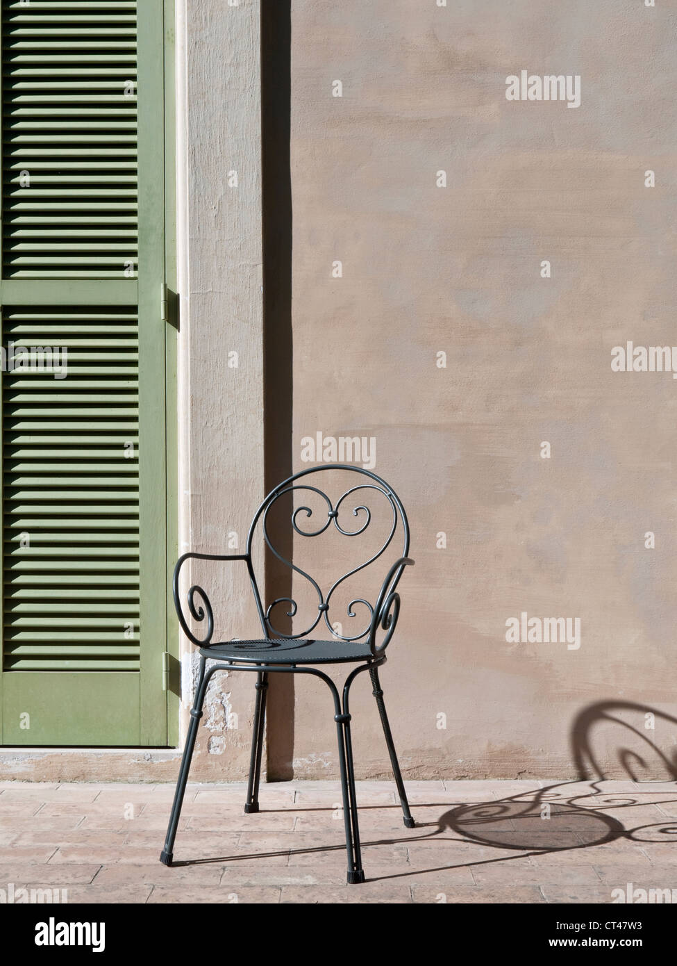 Persiane e ferro battuto sedia in sole e ombra, Grottaferrata, Roma, Italia Foto Stock