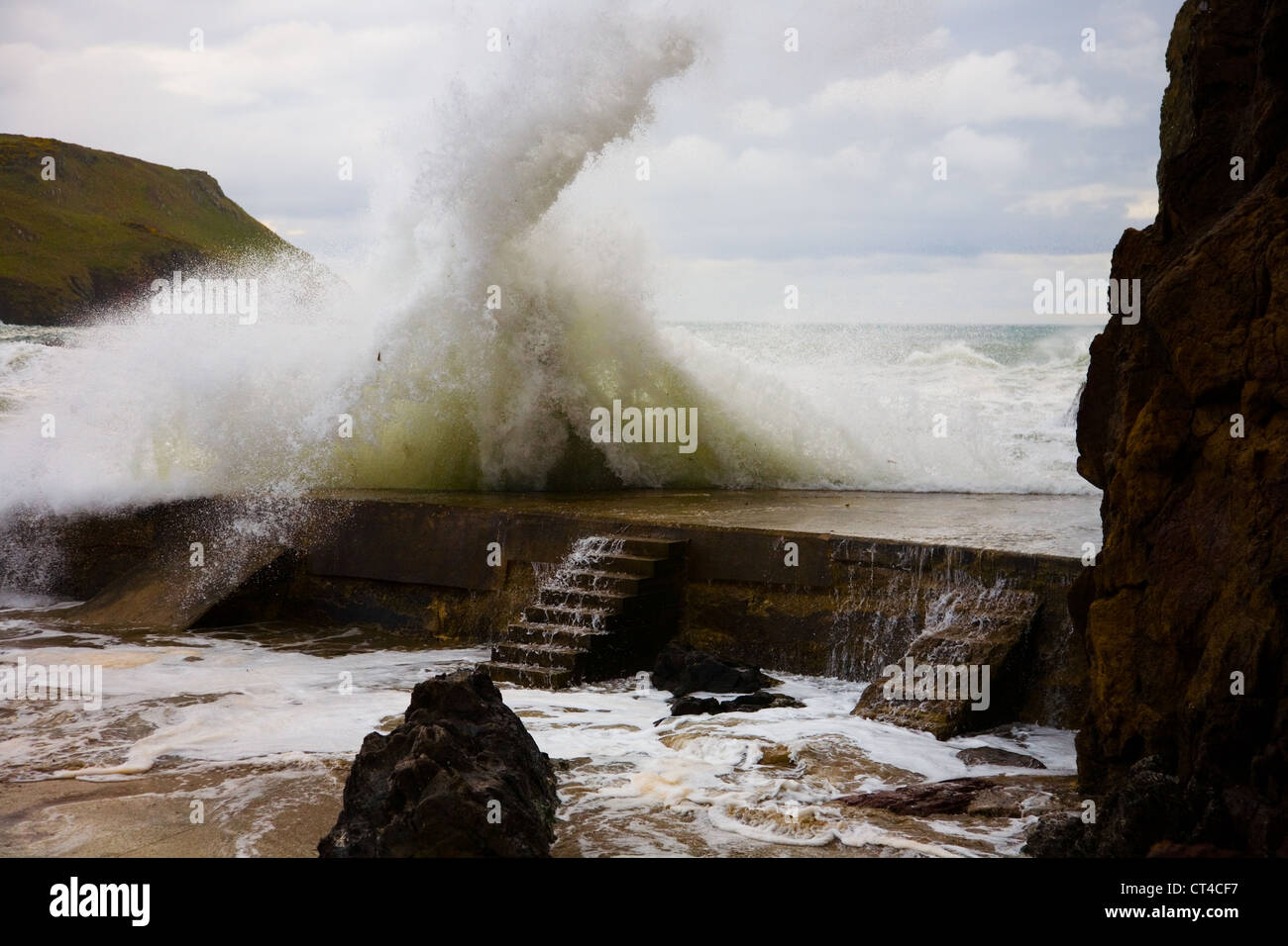 Una grande onda colpisce il frangiflutti a Hope Cove, South Devon Foto Stock