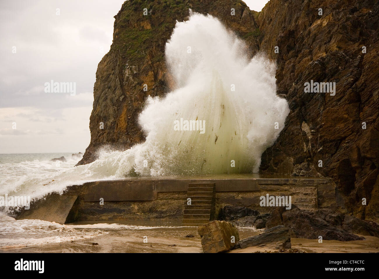 Una grande onda colpisce il frangiflutti a Hope Cove, South Devon Foto Stock