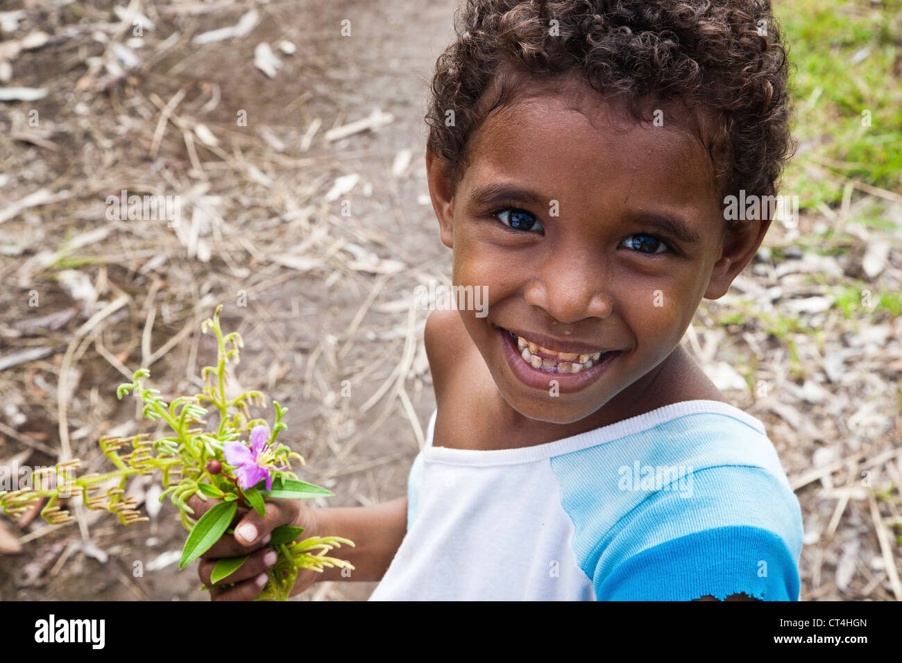 Indonesia, Papua Nuova Guinea, Fergusson isola. Close-up shot di ragazzo giovane azienda fiori. Foto Stock