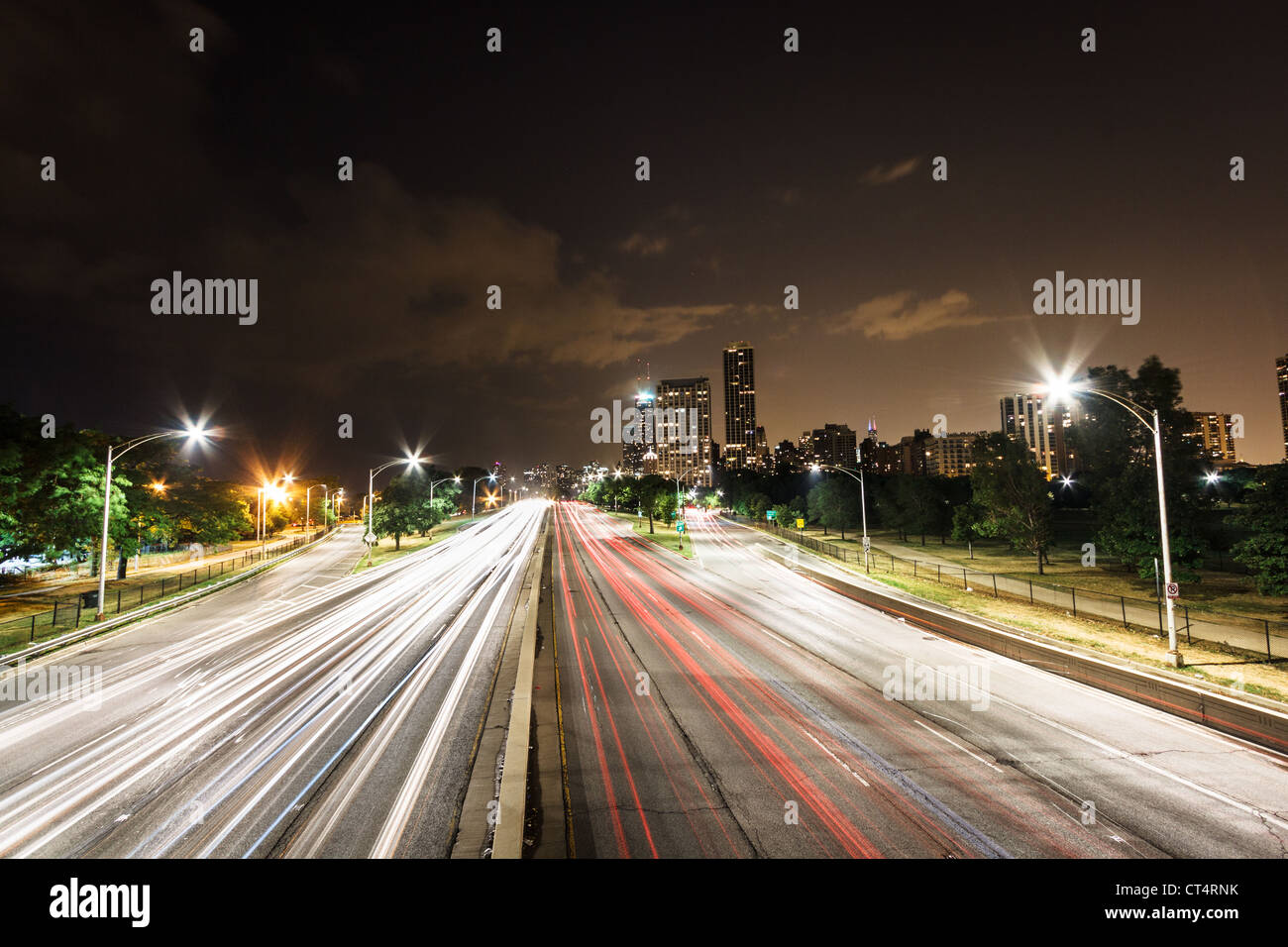 Auto sentieri di luce su Lake Shore Drive con la skyline di Chicago in background di Chicago, IL Foto Stock