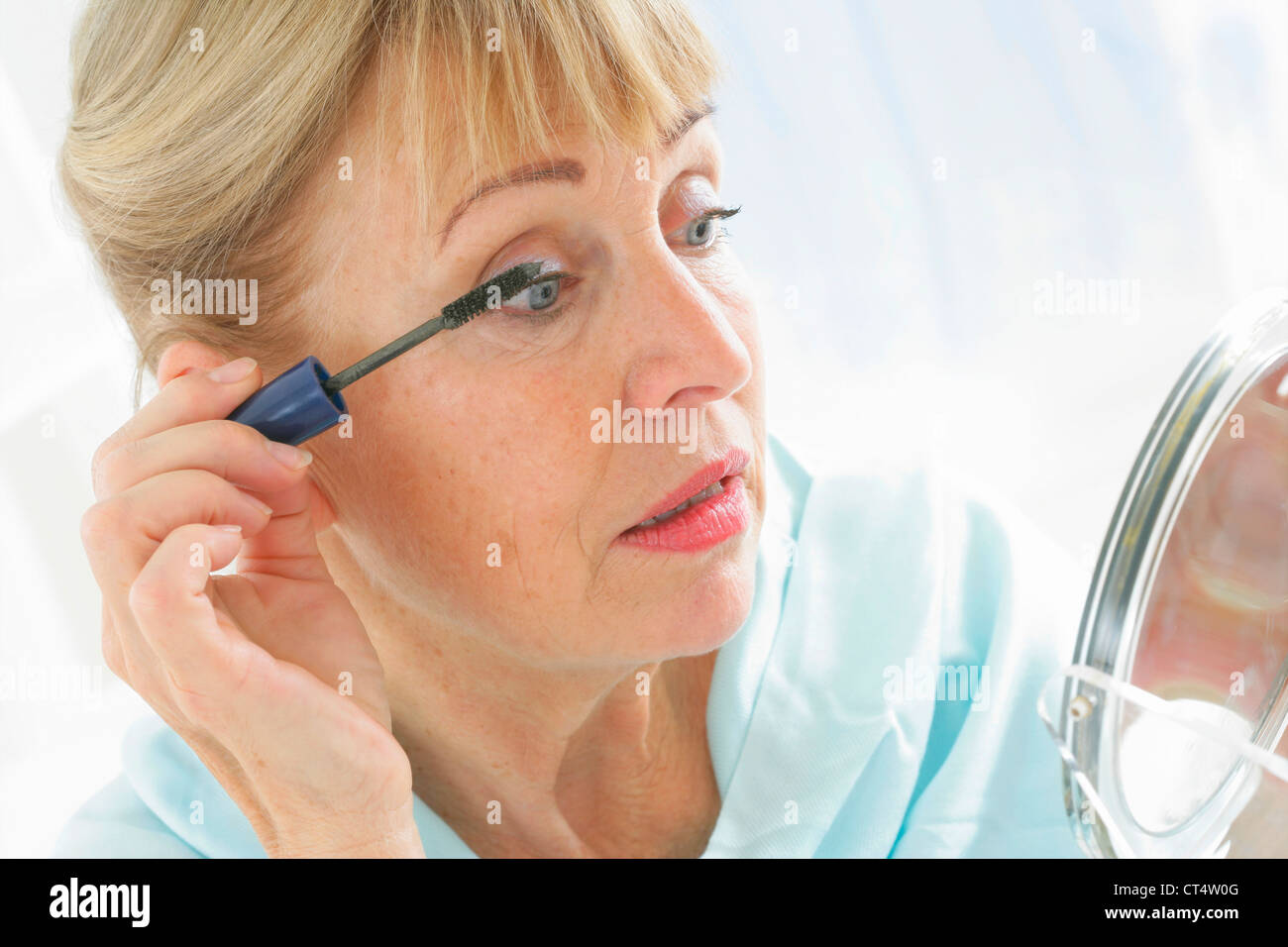 Donna anziana mettendo sul MAKE-UP Foto Stock