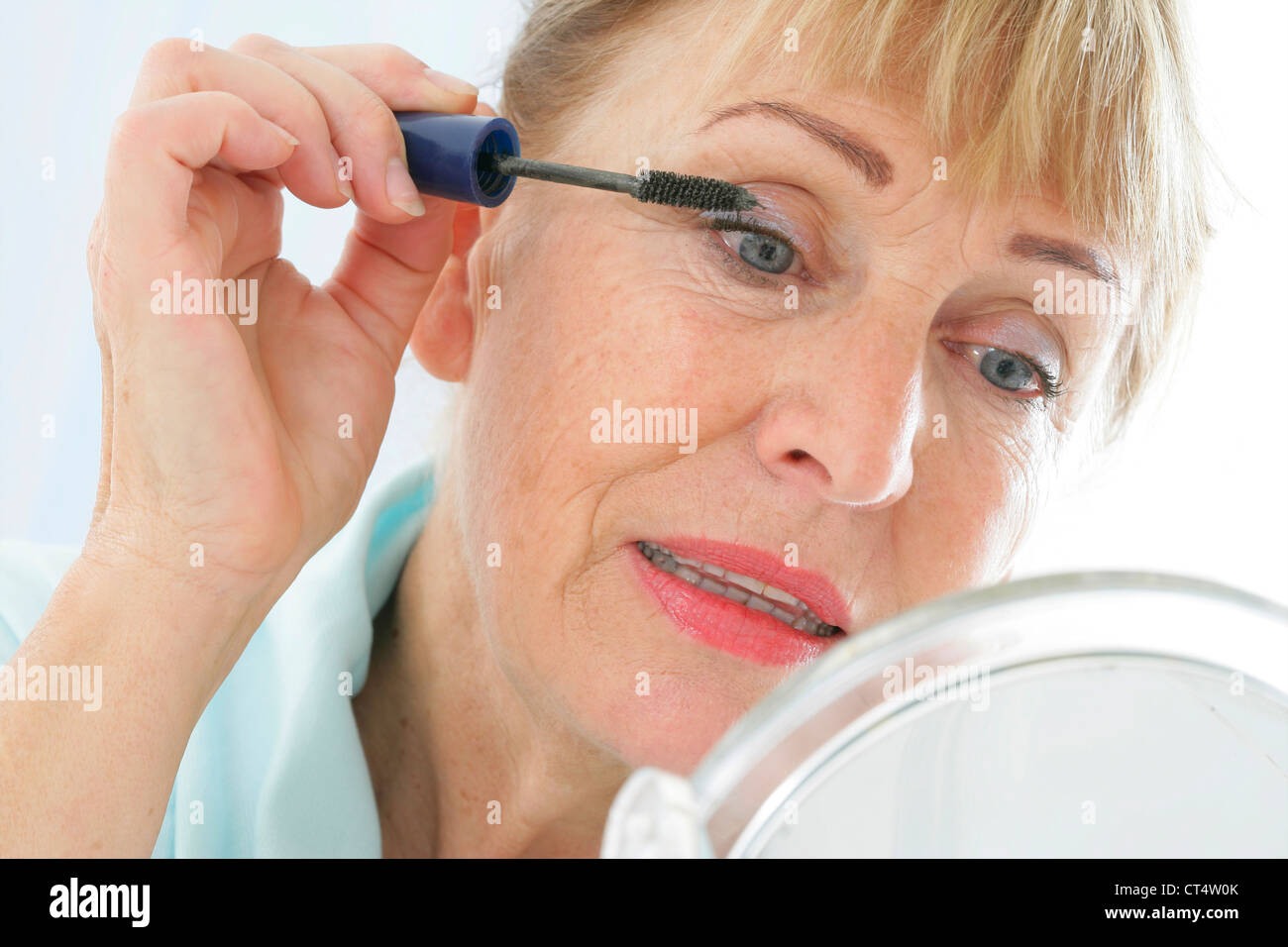 Donna anziana mettendo sul MAKE-UP Foto Stock