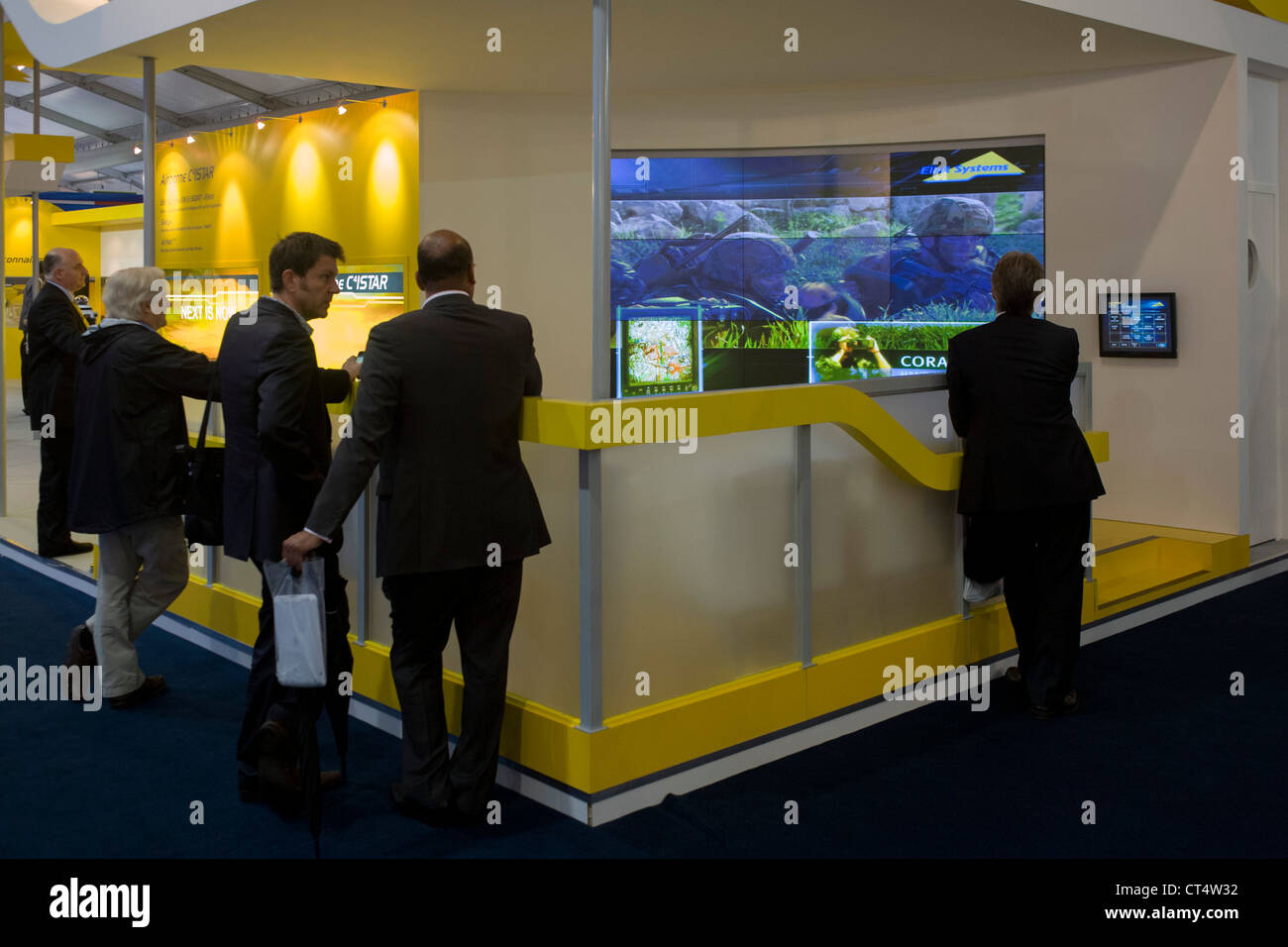 I delegati guardare film PR presso la società di elettronica Elbit Systems UK stand commerciali durante il salone di Farnborough, Regno Unito. Foto Stock