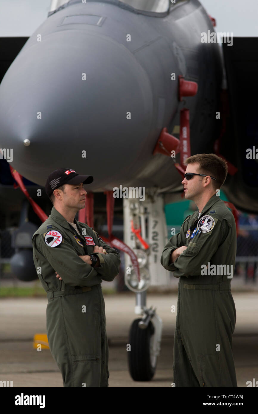 Due US Air Force equipaggio sostare al di sotto del naso del loro F-16C jet da combattimento al salone di Farnborough, Regno Unito. Foto Stock