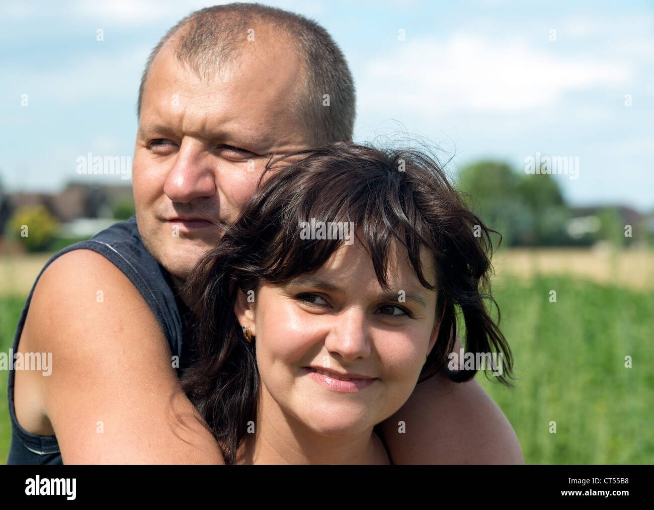Coppia giovane, l uomo e la donna in piedi all'aperto. Donna sorridente. L uomo è grave Foto Stock