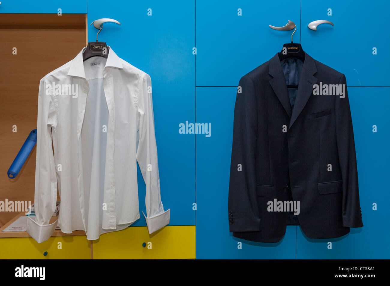 Sposo la camicia bianca e giacca appesi gli sportelli degli armadi Foto Stock